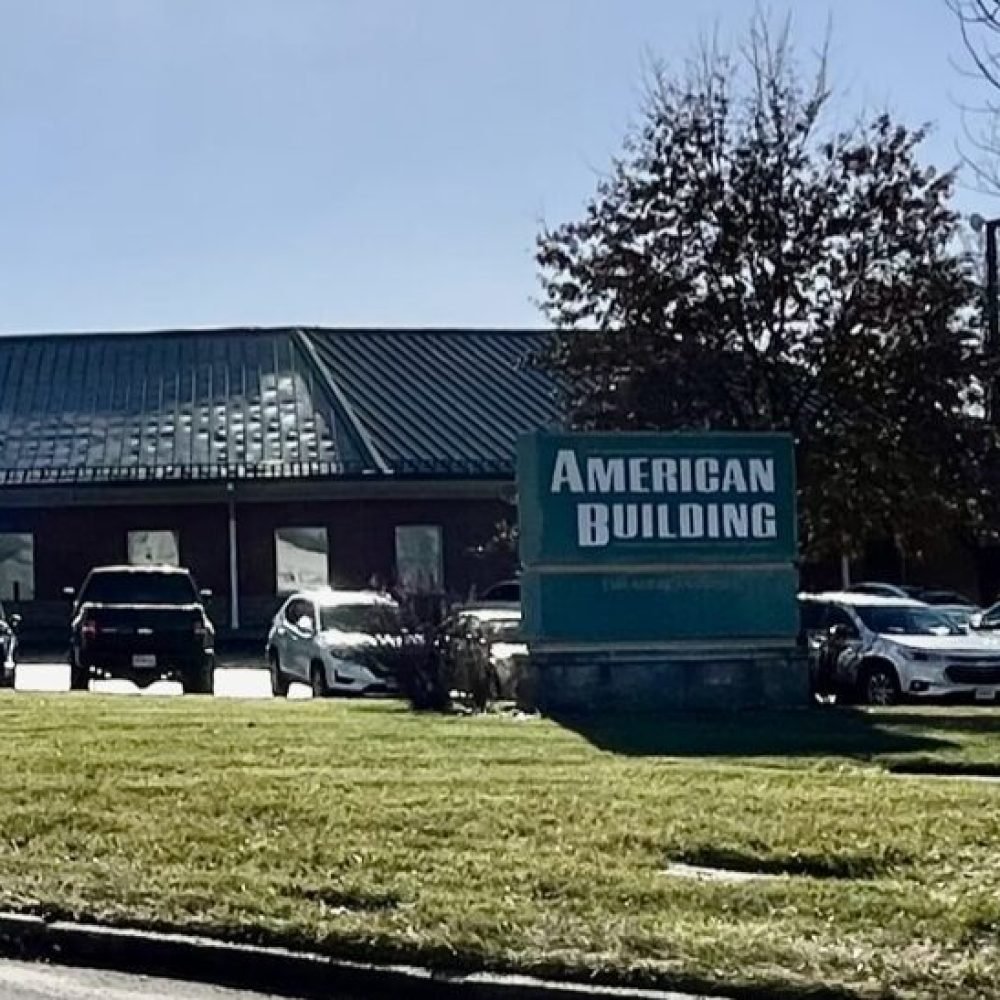 Green sign with white letters reading American Building in front of building