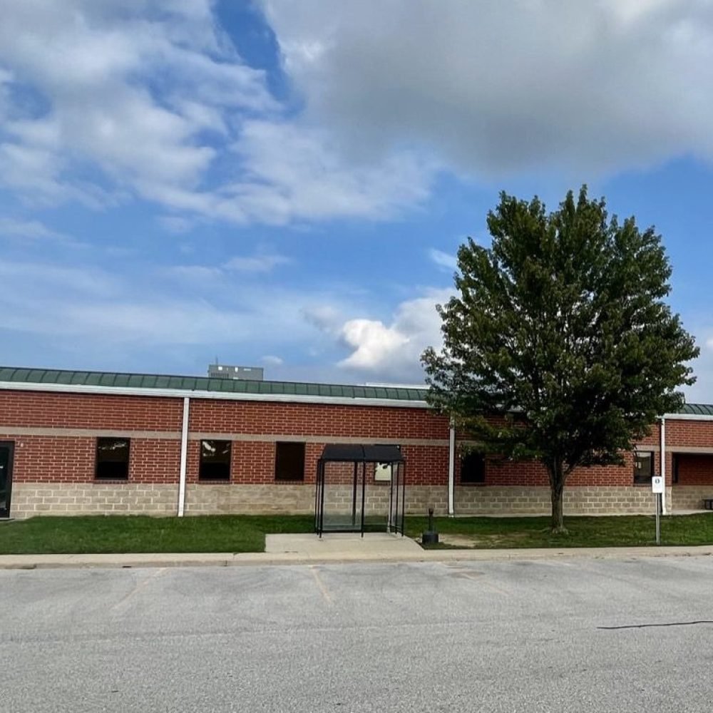 Papa Office side profile of brick building with tree in front